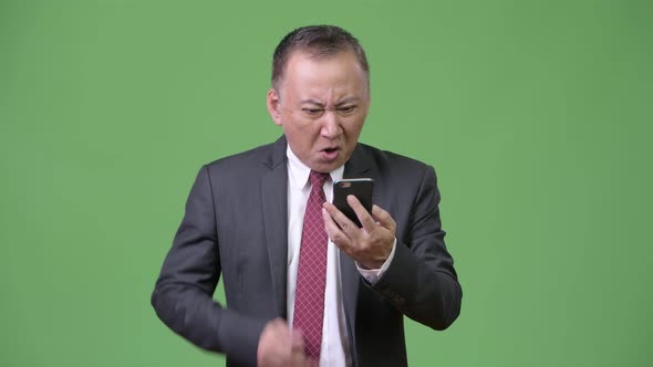 Mature Japanese Businessman Using Phone