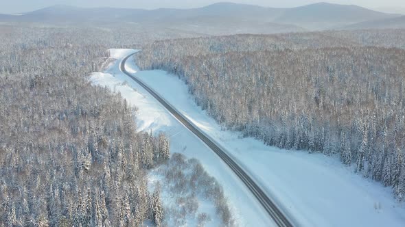 Highway Through the Winter Forest Aerial Photography From UAVs