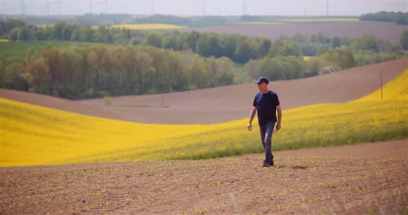 Agriculture - Farmer Walking on Field Examining Crops at Farm at Dusk