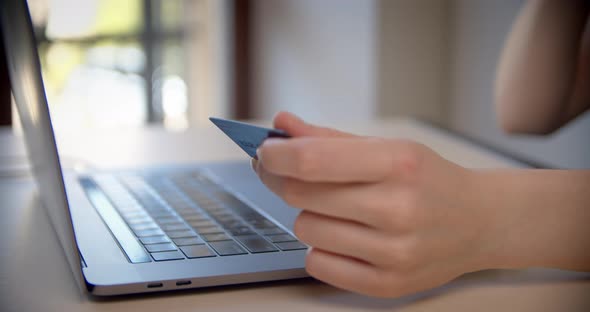 Close Up View of Young Woman Hold Credit Card Use Notebook Computer Typing Number Payments at Home