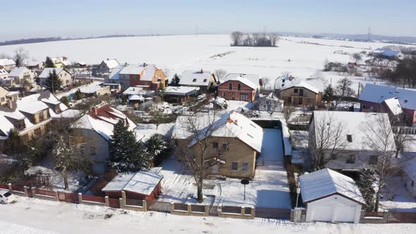 Aerial Drone Shot  Snowcovered Houses in a Village in Winter  Drone Turns to the Right