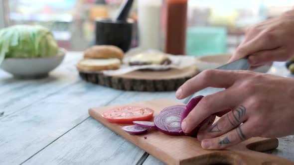 Hands Cutting Purple Onion.