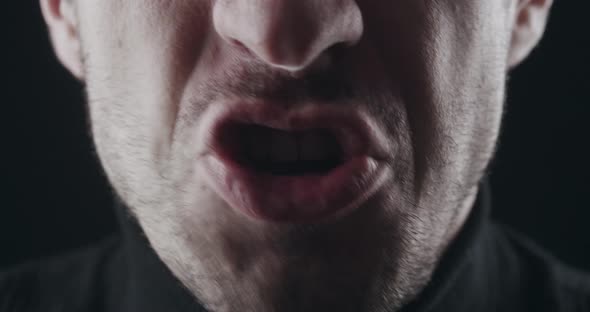 Closeup of Aggressive Man's Mouth Screams and Threatens with Violence