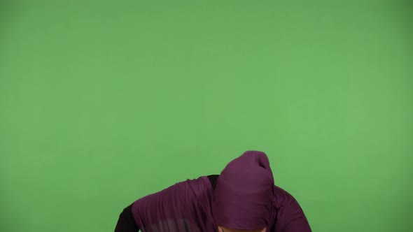 A Young Beautiful Muslim Woman Dances with a Smile  Green Screen Background