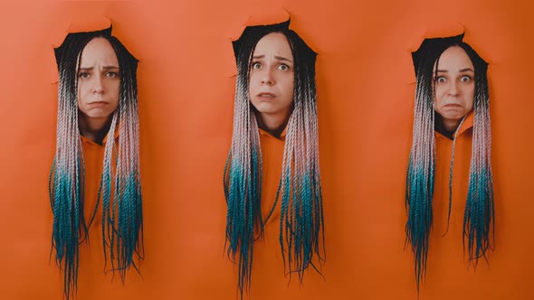 Young Woman with Different Emotions Sticking Out of Hole of Orange Background