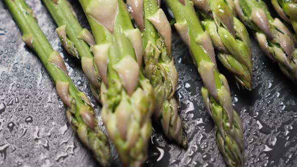 Raw Green Asparagus on Black Slate Background