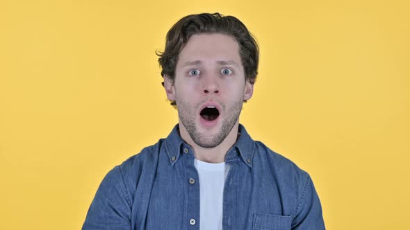 Disappointed Young Man Having Loss Failure Sign on Yellow Background