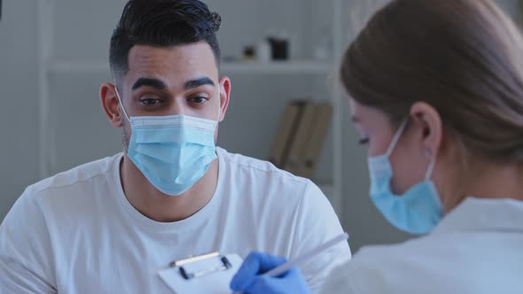 Arabic Man Hispanic Guy Patient Sick Male Wears Medical Protective Mask on Face Talks About Symptoms