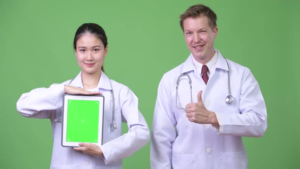 Multi-ethnic Couple Doctors Showing Digital Tablet Together