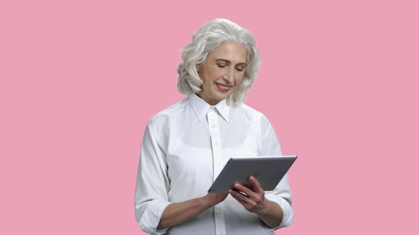 Smiling Senior Woman Using Digital Tablet.