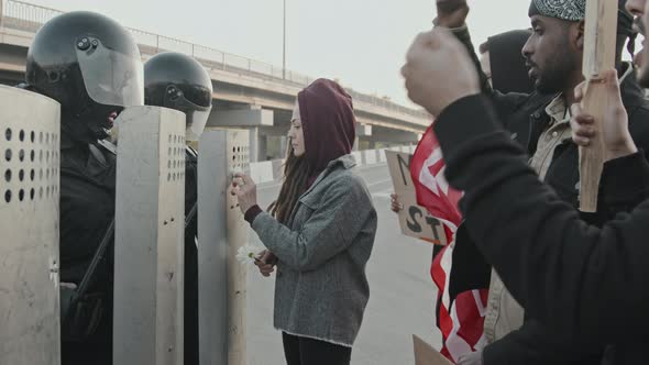 Protester Putting Flowers into Shields of Riot Policemen