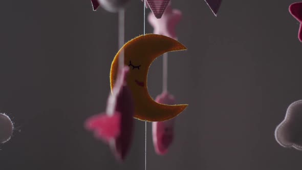 Baby Mobile with Pink Handstitched Animal and Bird Toys with Yellow Moon on White Wall Background