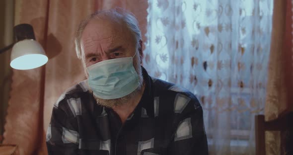 Ill Senior Man Sitting in Medical Mask Coughing and Worries About Health