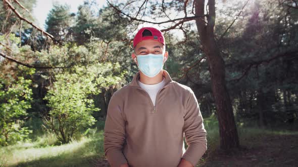 Young Asian Korean Tourist Man in Forest Wearing Medical Protective Mask Safe Travel Hiking in Park