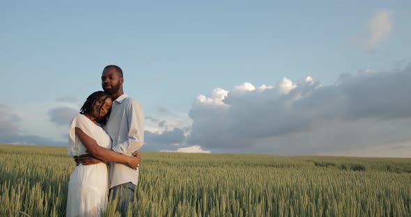 Happy Romantic Couple Hugging in a Summer Field