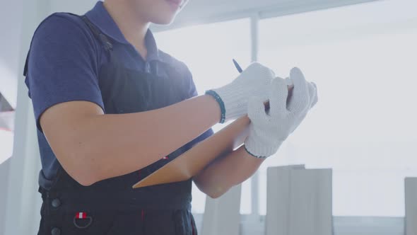 Close up of Asian construction worker male wear protective gloves, examine and check renovation plan