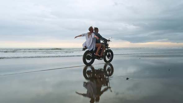 Young Beautiful Couple Hipsters Riding Retro Motorcycle on the Beach, Outdoor Portrait, Riding Guy