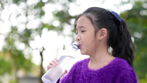 Beautiful Asian Girl Drinks Water From A Bottle Outdoors