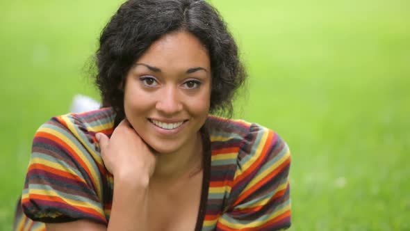 Portrait of young woman laying in grass