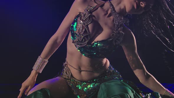 Wet Oriental Woman Sitting on the Surface of the Water and Dancing a Belly Dance