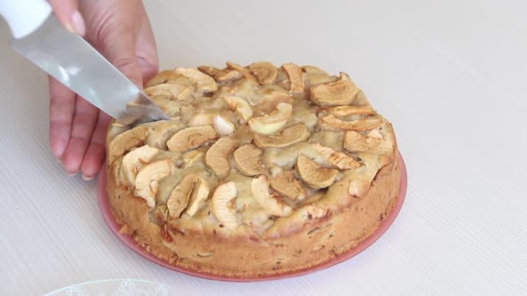 A Woman Cuts A Baked Apple Pie. Cooking Charlotte At Home. Shooting The Camera On The Slider.