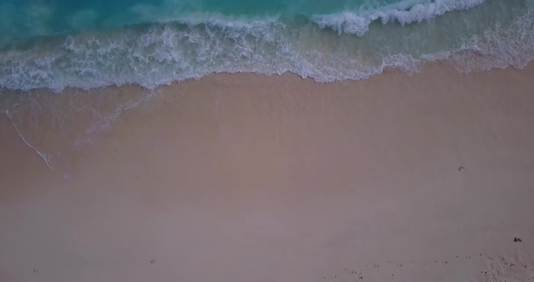 Daytime overhead travel shot of a sandy white paradise beach and aqua blue ocean background in hi re