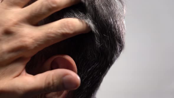 An Elderly Man Runs His Hand Through His Gray Hair