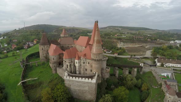 Aerial view of Corvin Castle surrounded by a greenland