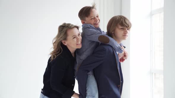 A Mother with Two Sons in Blue Clothes Have Fun and Poses for a Photo Shoot