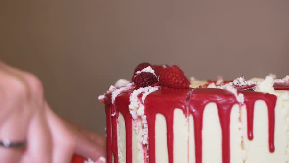 Cut the Cake Covered with Red Cured Cream with a Pastry Knife with Serrated Blades