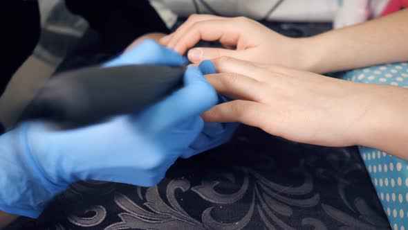 The Manicurist Makes Manicure Procedure of Recovery and Nail Extensions on the Nails of the Girl in