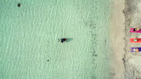 Aerial view of photographer in sea near sandy beach in summer.