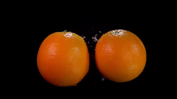 Two Oranges are Colliding with Each Other on the Black Background