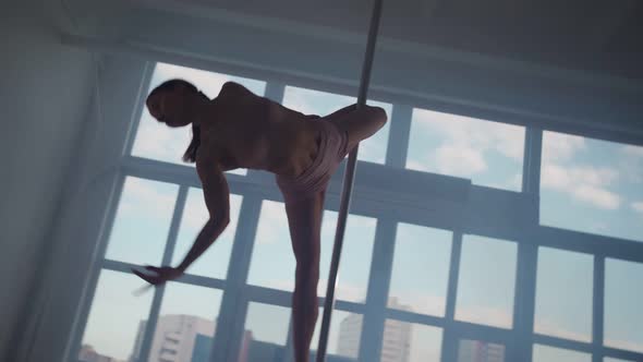 Athletic Woman Pole Dancer Performs Spectacular Tricks on Pole