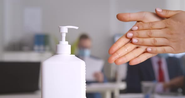 Cropped Shot of Female Office Worker Using Antibacterial Antiseptic Gel for Hands Disinfection