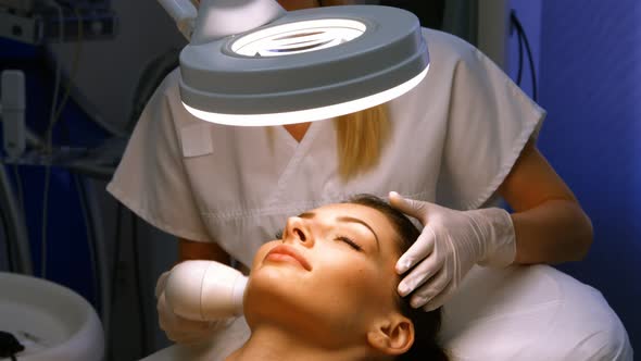 Doctor giving facial massage through soniclifting