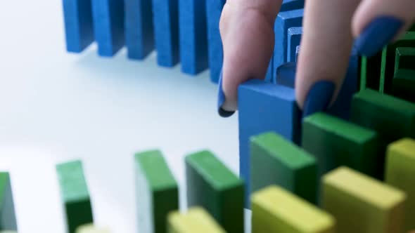 Line up of Dominoes in Rainbow Falling Colors with LGBT Colors of a Hand