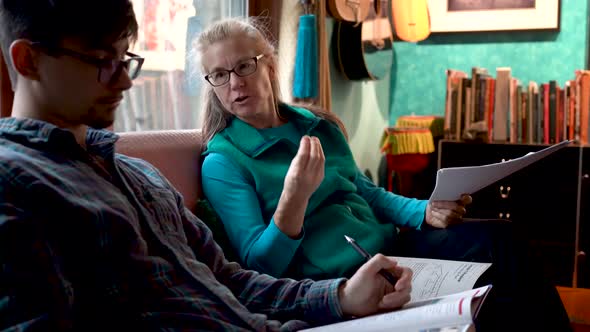 Closeup of homeschool mom talking to her son as they review homework assignments.