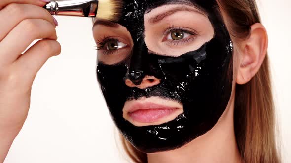 Girl Applying Black Carbo Mask to Face