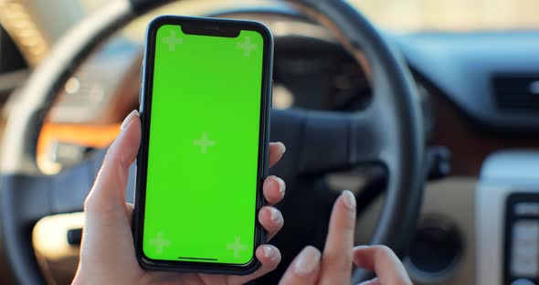 Woman Using Smartphone with Green Screen Chroma Key Inside Car