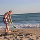 a Boy Digs Sand on the Beach with a Plastic Scoop or Shovel - VideoHive Item for Sale