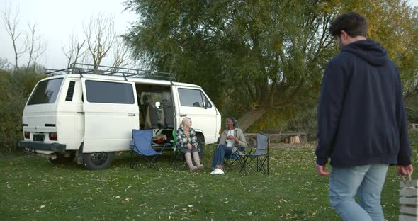 Four Friends Near a Camper Van By the River