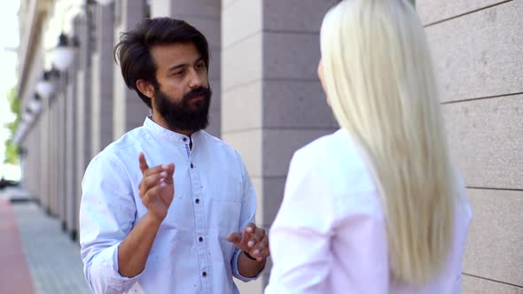 Closeup Side View of Unrecognizable Business Woman and Bearded Business Man Talking Outdoors By