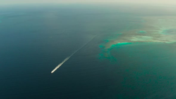 Seascape, Coral Reef and Blue Sea with Motorboat. Balabac, Palawan, Philippines.