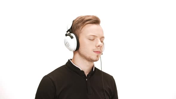 Young Handsome Man Listening Music in Headphones Dancing Singing Over White Background