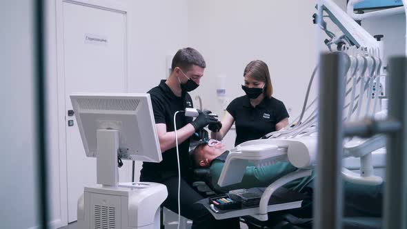 Dentist and Assistant Do an Operation for a Patient