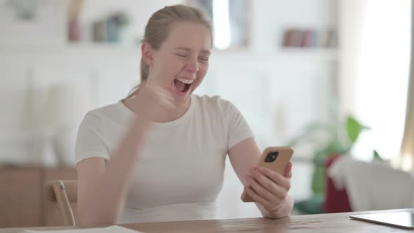 Successful Beautiful Young Woman Celebrating on Smartphone