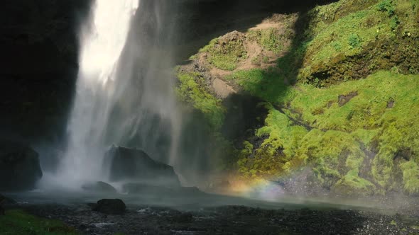 Man playing guitar in front of a beautiful waterfall in Iceland. SlowMo and real time shots from the