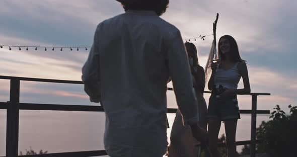 Group of friends drinking wine at sunset