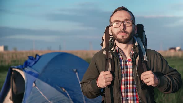 Portrait of Guy with Backpack Posing at Camping Tent Background